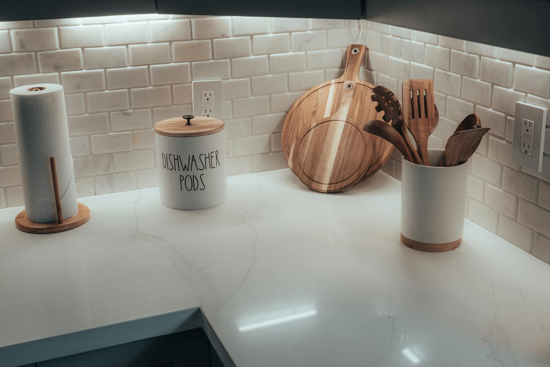 Minimalistyczny kącik kuchenny z deskami do krojenia i kapsułkami do zmywarki